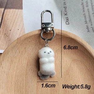 Gros plan d'un porte-clés loutre mignon avec dimensions de 6,8 cm sur un plateau en bois