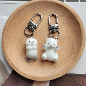 Détail de porte-clés loutre et ours blanc floqués avec anneau en D argenté