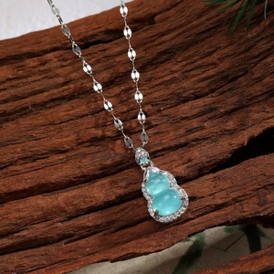 Detailed close-up of light green gourd pendant with zircon inlay on silver chain