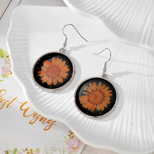 Round resin drop earrings with orange dried daisy flowers and silver hooks for women