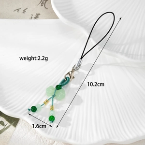 Detail view of green beaded phone charm with a bow pendant showing exact size and weight