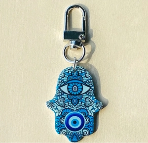 Dettaglio di portachiavi Hamsa in acrilico con motivi Evil Eye e chiusura argento