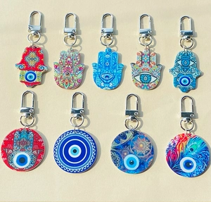 Dettaglio di ciondoli colorati in acrilico Hamsa e Evil Eye con moschettoni in argento