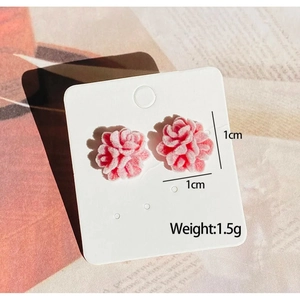 Vue détaillée de boucles d'oreilles fleurs floquées dégradé rose et blanc sur carte