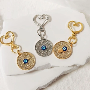Dettaglio di portachiavi Occhio di Allah con strass e moschettoni a cuore oro e argento