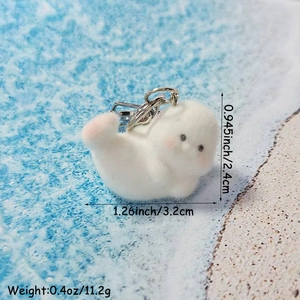 Cute white flocked seal keychain charm with metal ring on blue beach background