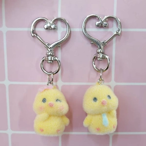 Close-up of cute yellow flocking chick keychains with heart-shaped metal lobster clasps