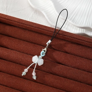 Handmade gourd phone charm with soft pastel beads and blue woven knot on velvet tray