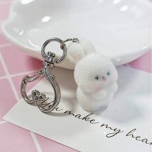 Cute white flocked bunny keychain with silver lobster clasp on a pink checkered background