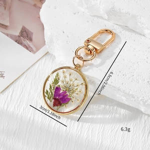 Handmade clear resin keychain with purple dried flowers and gold metal hardware