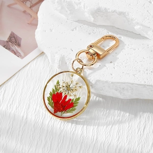 Detailed macro of a handmade resin keychain with real dried flowers and gold metal frame