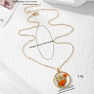 Vue détaillée du pendentif rond en résine avec fleurs séchées, dimensions et longueur