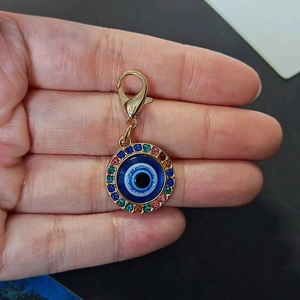 Detail showing the Evil Eye pendant with colorful rhinestones and gold lobster clasp