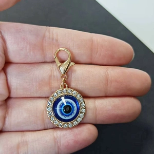 Ciondolo malocchio dorato con strass blu e chiusura a moschettone per chiavi