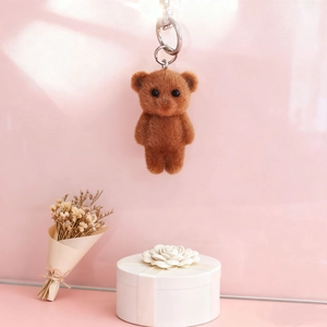Porte-clés ours floqué marron sur fond rose avec décoration élégante de boîte cadeau blanche