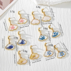 Detail showing cloud resin earrings with real dried flowers and size measurements