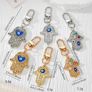 Makroaufnahme von Hamsa Hand Schlüsselanhängern mit Evil Eye Emaille und Kristallen