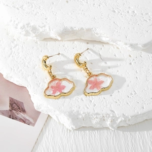 Close-up of cloud resin earrings with real pink dried flowers and gold moon hooks