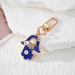 Detailed view of Hamsa Hand keychain with blue enamel, crystals, and gold plating