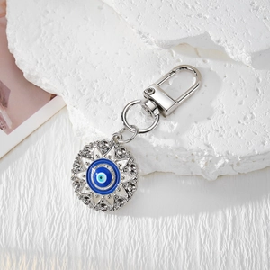 Silver Evil Eye sunburst keychain with blue enamel and sparkling crystals on white stone