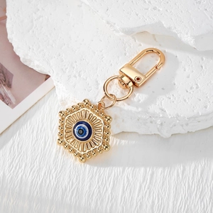 Golden Evil Eye Hamsa Hand keychain with blue Turkish eye pendant on white stone
