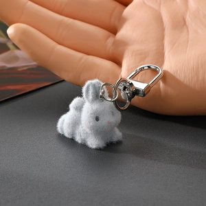 Gros plan d'un adorable porte-clés lapin gris floqué avec un fermoir en métal argenté