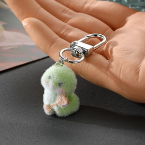 Cute green plush little monster keychain accessory with soft faux fur and silver hook