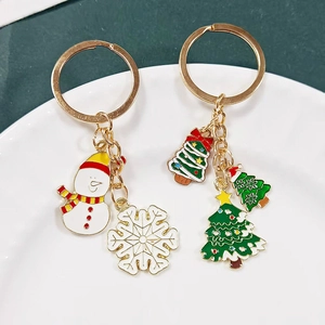 Christmas keychains featuring snowman and festive tree charms in gold-tone alloy