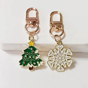 Set di portachiavi natalizi con albero verde e fiocco di neve bianco su base dorata