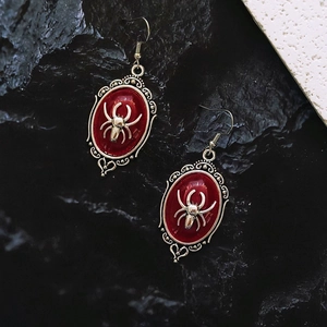 Close-up of gothic spider earrings with red oval resin and vintage silver filigree