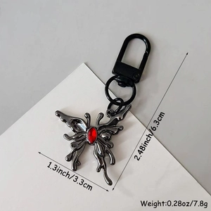 Vue détaillée du porte-clés papillon gothique avec gemme rouge et design fluide