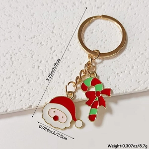 Detailed macro view of Santa Claus and candy cane enamel charms on a festive keychain