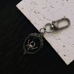 Gothic silver spider oval pendant keychain with vintage Victorian floral engraving detail