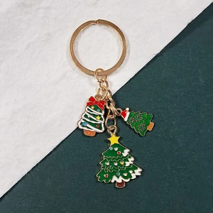 Detail of Christmas tree keychain with gold metal ring and green enamel charms