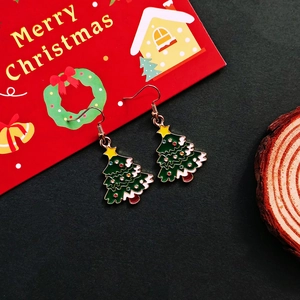 Detailed Christmas tree earring with green drip oil and gold hook on a festive backdrop