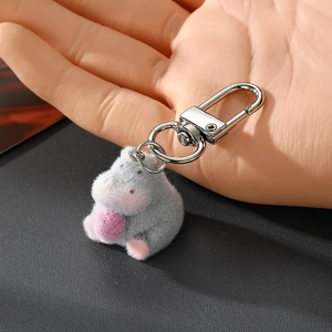 Gros plan détaillé d'un porte-clés hippopotame gris floqué avec un petit ballon rose