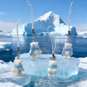 Set of four flocking polar bear keychains with blue scarves on ice background