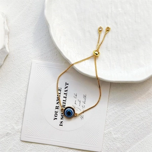 Bracelet œil porte-bonheur doré ajustable avec breloque en émail bleu et détails zircon