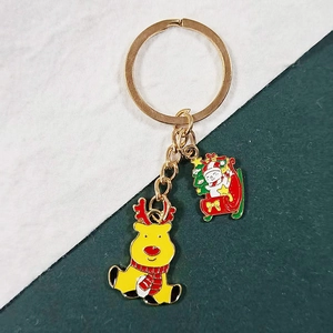 Detail of Christmas keychain with yellow reindeer and snowman on a red sleigh charm