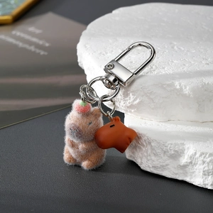 Detail of Capybara keychain featuring flocking texture and dark brown resin pendant charms
