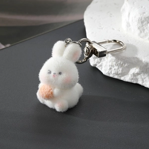 Close-up of white flocked rabbit keychain with orange carrot and silver D-ring