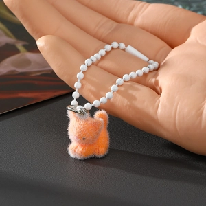 Niedlicher orangefarbener beflockter Katzen Schlüsselanhänger in der Hand gehalten
