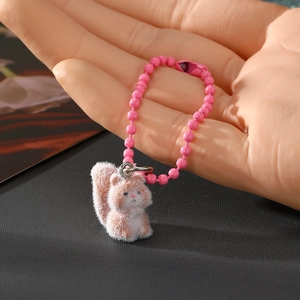 Nahaufnahme eines flauschigen Eichhörnchen-Schlüsselanhängers mit rosa Perlenkette