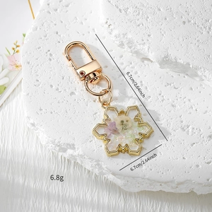 Detailed snowflake keychain with dried flowers in resin and dimensions 6.7cm