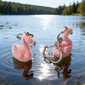 Cute pink plush flamingo keychains with silver heart ring on sparkling lake water
