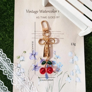 Realistic cherry keychain with red beads, green leaves and golden bow ornament for bags