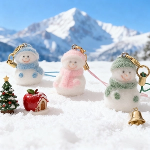 Three cute flocking snowman phone charms with colorful knit hats in a winter snowy scene