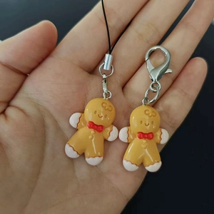 Handheld set of two resin gingerbread man charms with black cord and silver lobster clasp
