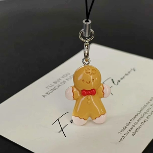 Handmade gingerbread man resin charm with red bow and black lanyard for bags and phones
