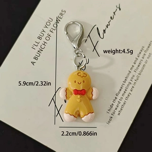 Detailed view of handmade gingerbread man charm with lobster clasp on white display card